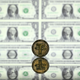 A Tether coin mirrored amid a backdrop of U.S. dollar bills.